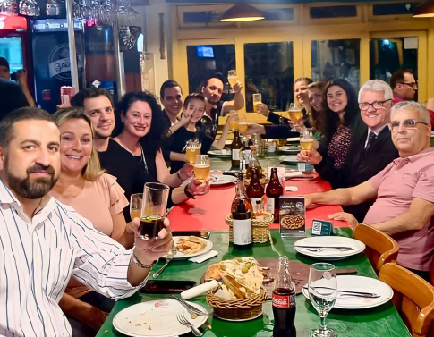 Colaboradores(as) atuais e antigos(as) comemorando os 15 anos da Caminhos em uma pizzaria no fim do ano passado.